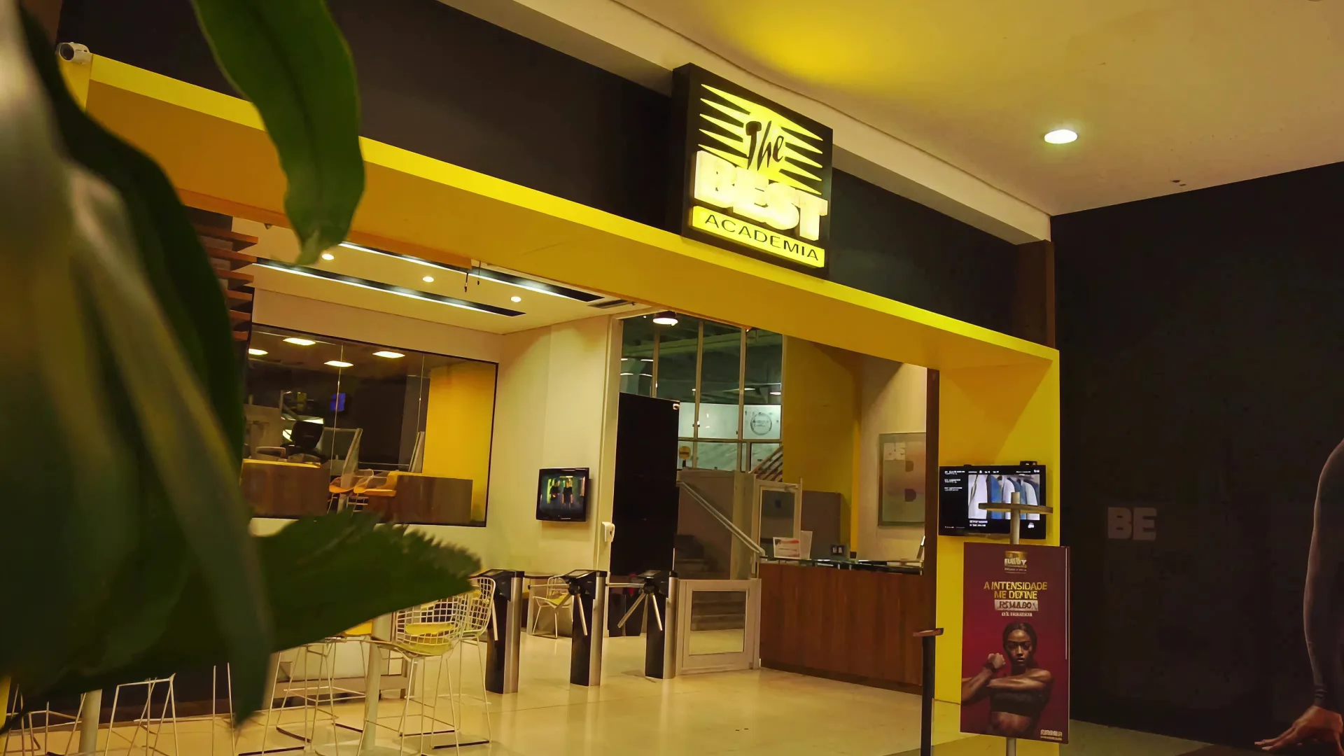 Lanchonete e área de convivência da The Best, com mesas, cadeiras e café